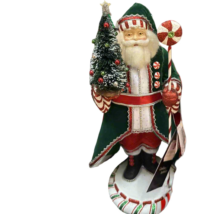 Decorative figure of Santa Claus holding a small Christmas tree and candy cane on a white background
