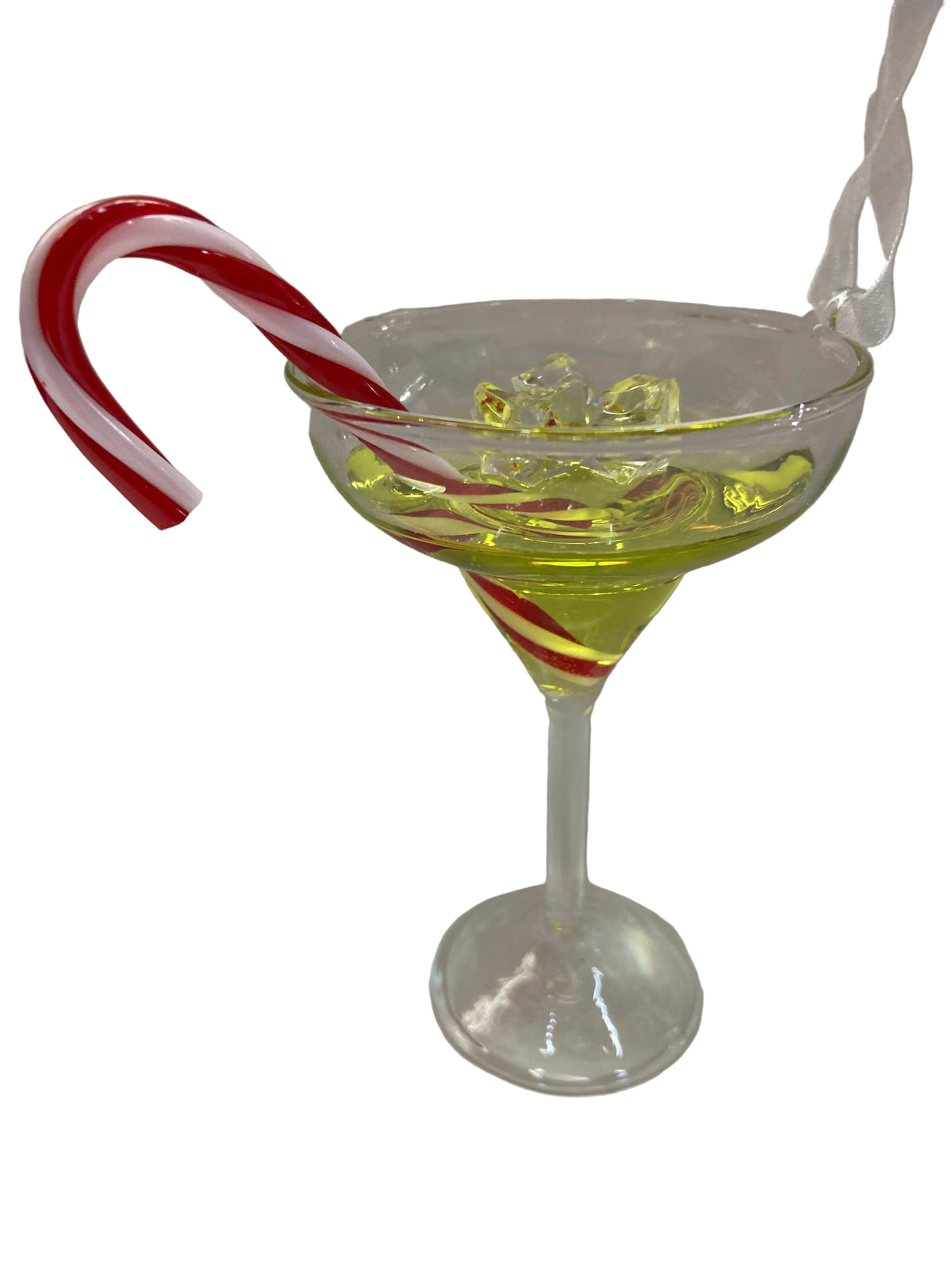 A clear glass martini-style coupe filled with pale yellow liquid and ice, garnished with a red-and-white striped candy cane on the rim, photographed against a plain light background.