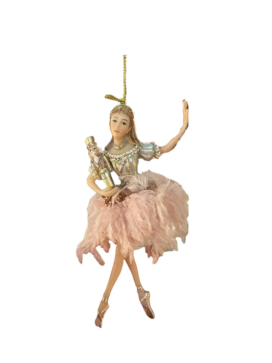 Decorative fairy figurine with pink dress held in front of a glass display case.