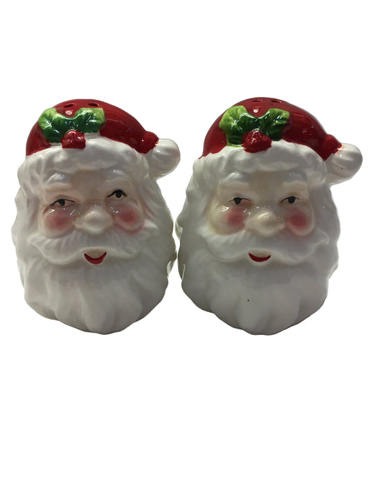 Two ceramic Santa Claus faces on a white background