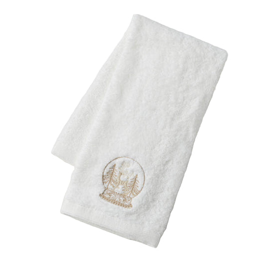 White towel with gold snow globe design on a light gray background