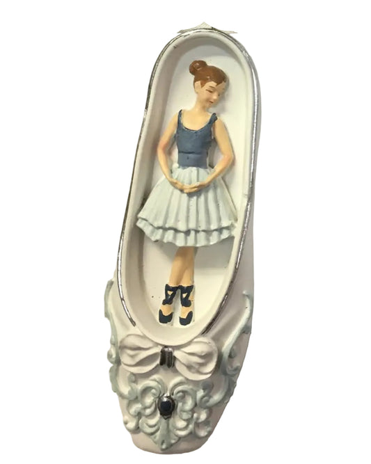 A ballet shoe Christmas ornament featuring a painted ballerina figure inside, with a white ribbon loop and a black retail price tag attached, photographed on a white background.
